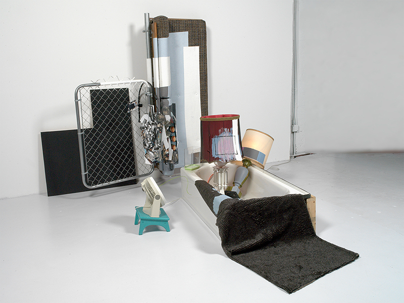 Jessica Stockholder’s monumental work "2000" comprises a bathtub, sofa, accent lamps, and other household objects.